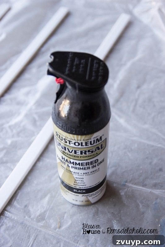 Spray painting polystyrene moulding pieces with hammered black paint for shower door grid.