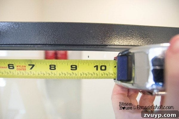 Measuring and marking the glass shower door for vertical moulding placement using a black permanent marker.
