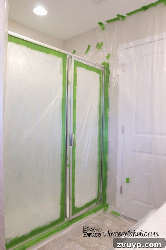 Masking off a shower for spray painting during industrial factory window shower door DIY.