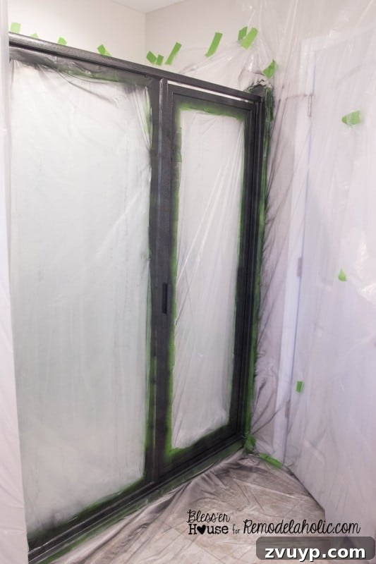 Third and final coat of hammered black spray paint on a shower door frame, showing full coverage.