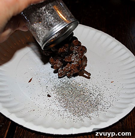 Craft Your Own Pinecone Ornaments 3 Sprinkling Glitter onto a Glued Pinecone