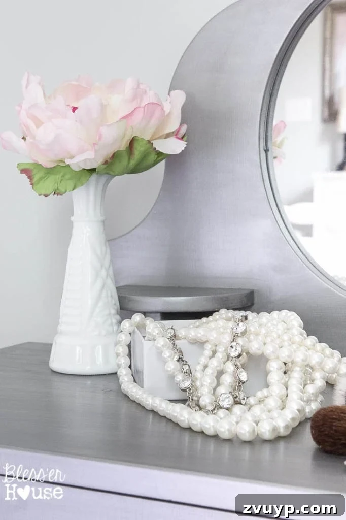 En Pointe Perfection: Her Ballerina Bedroom Makeover 16 Little girl trying on jewelry at her gilded play vanity, a playful moment in her ballerina-themed room.