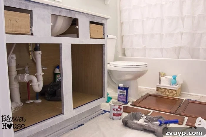 Effortless Cabinet Transformation for Beginners 11 Applying primer to cabinet doors and frames using a brush and foam roller.