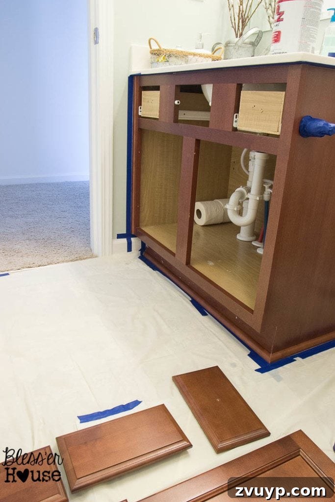 Effortless Cabinet Transformation for Beginners 8 Protecting the floor and surrounding area with drop cloths and painter's tape before cabinet painting.