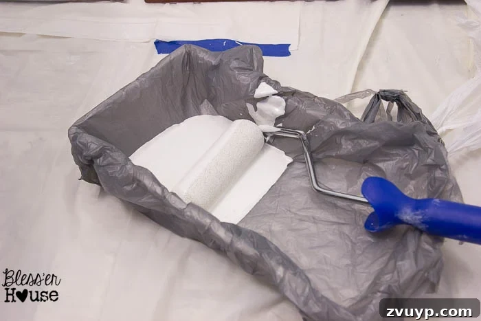 Effortless Cabinet Transformation for Beginners 10 Lining a paint tray with a plastic bag for easy cleanup.