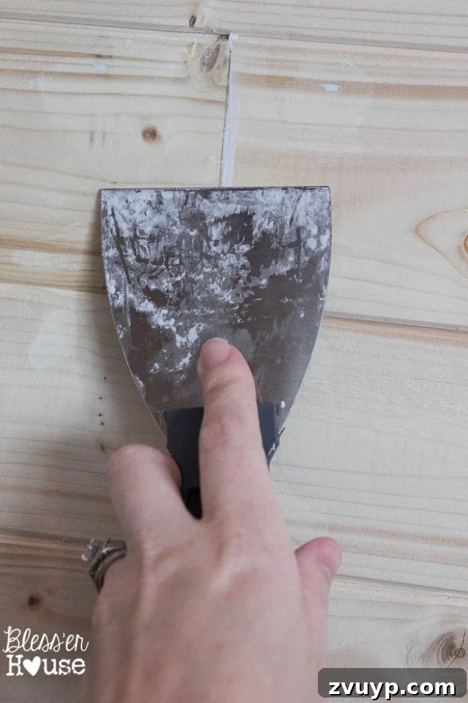 DIY Faux Shiplap Wall for Instant Farmhouse Charm 13 Sanding spackled nail holes on shiplap