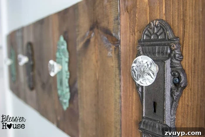 Upcycled Door Knob Towel Hooks 8 DIY Antique Door Knob Towel Rack | Bless'er House: The completed antique door knob towel rack mounted on the wall in a light blue bathroom, with towels hanging.