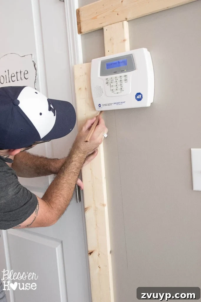 Effortless & Affordable Board and Batten DIY 15 Using a jigsaw to notch out a batten board for a light switch