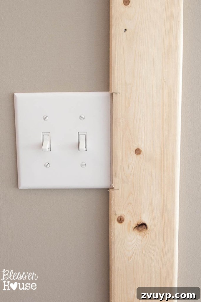 Effortless & Affordable Board and Batten DIY 16 Carefully notching out a batten board for an electrical outlet using a jigsaw for a custom fit