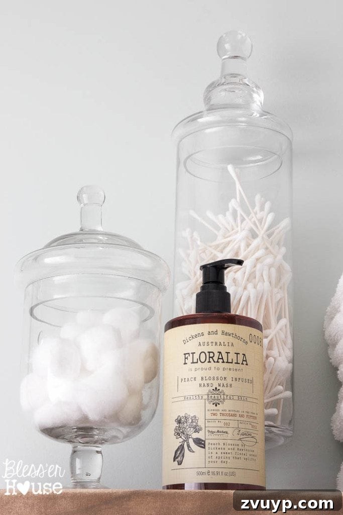 Chic Modern Farmhouse Bathroom Remodel Tour 14 Apothecary jars for stylish and child-safe storage of cotton balls and Q-tips in the farmhouse bathroom.