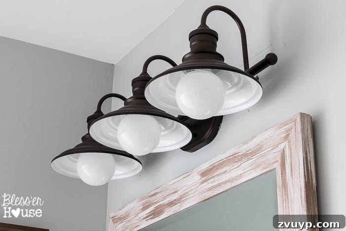 Chic Modern Farmhouse Bathroom Remodel Tour 16 New vanity light fixture casting a warm ambiance in the modern farmhouse bathroom.