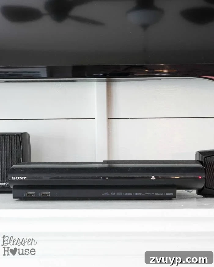 Elevate Your Mantel: Smart Ways to Conceal Electronics 4 Close-up of a white CordMate channel discreetly hiding TV wires on a wall under the television, blending in with the room's trim.