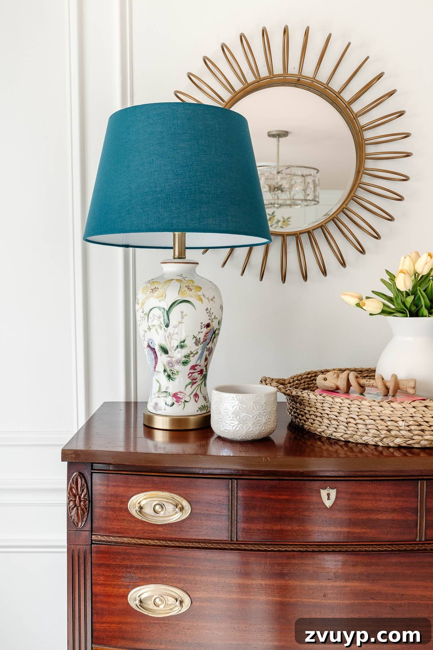 polished wood dresser with antique bail pulls and chinoiserie lamp on top