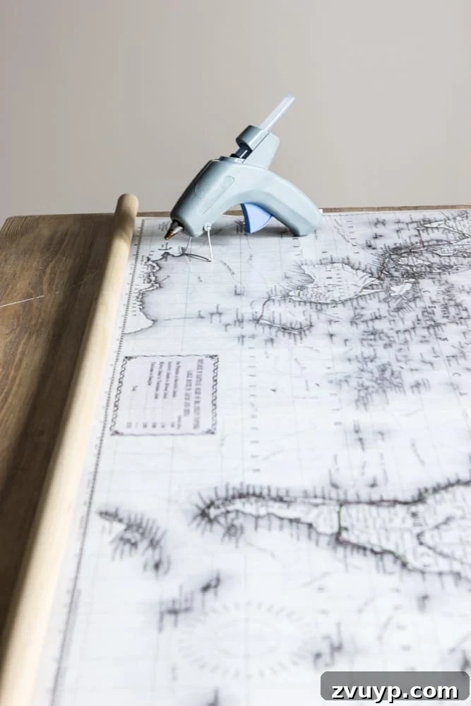 DIY Vintage Scroll Map 4 DIY Vintage Map Dowel Attachment | Easy steps to attach wooden dowels to your map poster using hot glue. Perfect for creating a professional-looking pull-down map with a vintage flair. Clear instructions for a smooth finish.