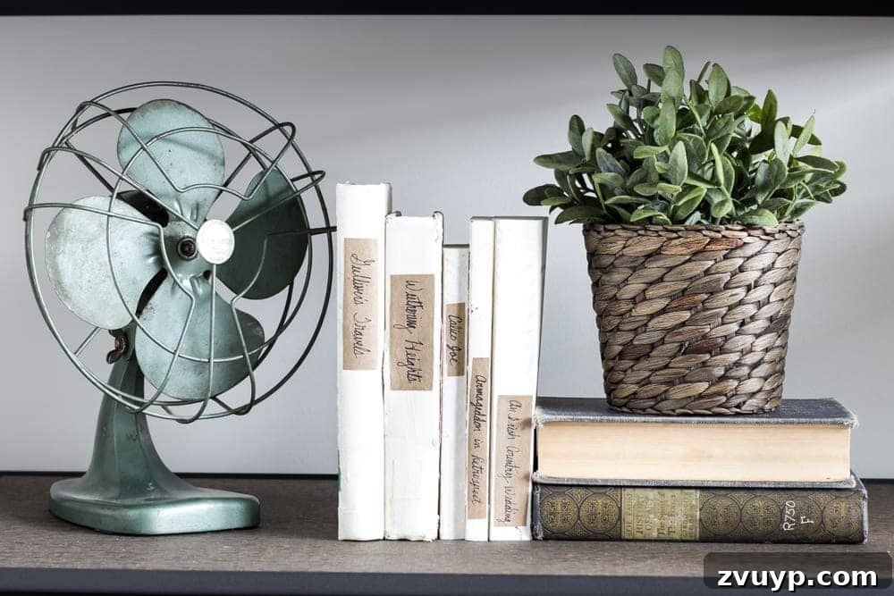 Close-up of elegant book styling with white chalk-painted books on industrial shelves