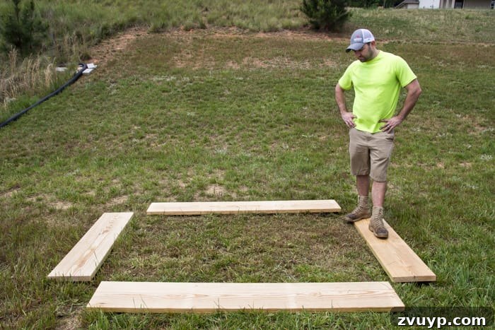 Bountiful Beds: Master High-Yield Raised Bed Vegetable Gardening 8 pine boards in a backyard laid out for building a raised bed vegetable garden frame