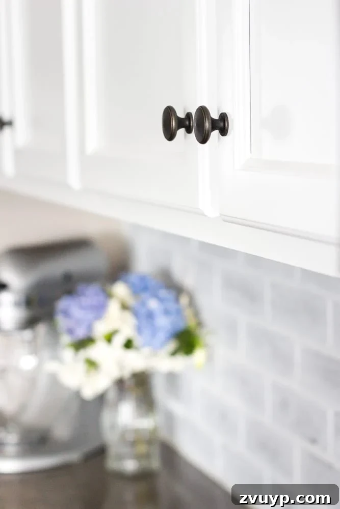 Flawless Cabinets: Paint Your Kitchen Like a Seasoned Pro 13 Bright white painted kitchen cabinets with new hardware and updated appliances. See the stunning transformation with this DIY cabinet painting method.