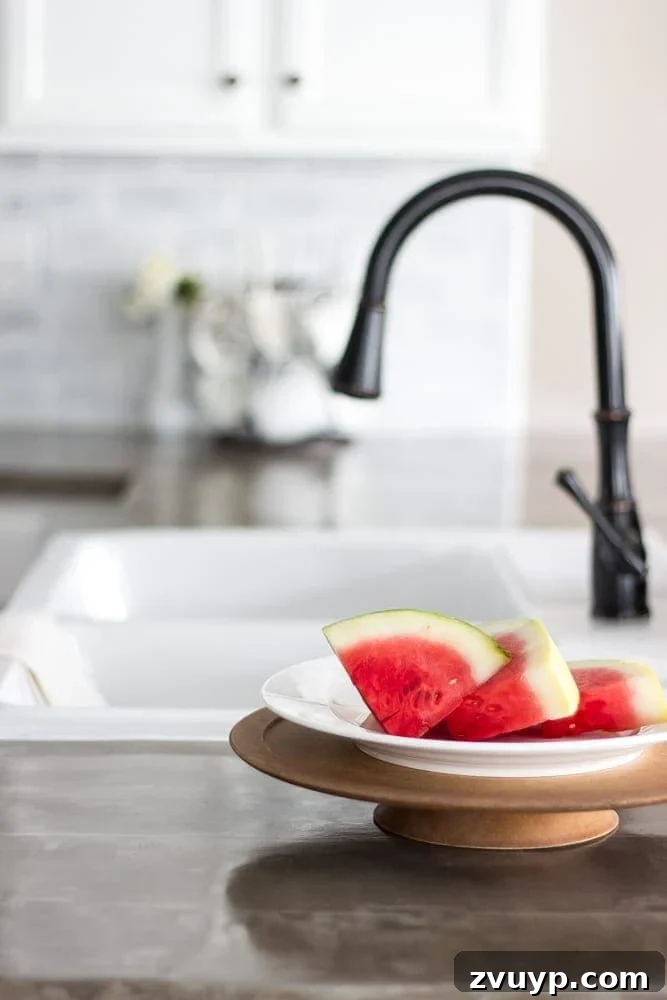 Flawless Cabinets: Paint Your Kitchen Like a Seasoned Pro 16 DIY concrete countertops with an IKEA farmhouse sink, complementing the newly painted white kitchen cabinets.