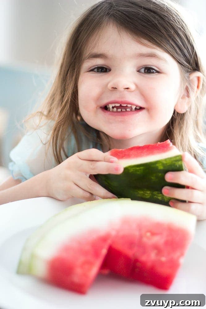 Flawless Cabinets: Paint Your Kitchen Like a Seasoned Pro 19 Child enjoying watermelon in a bright, newly painted kitchen. Highlights the everyday use and durability of DIY painted cabinets.