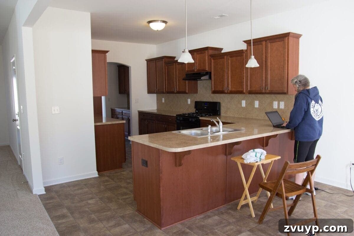 Our Stunning Modern Farmhouse Kitchen Transformation 2 Our kitchen's original dark and uninspiring builder-grade look upon moving in. A dated stainless steel sink and dark wood cabinets dominated the space.
