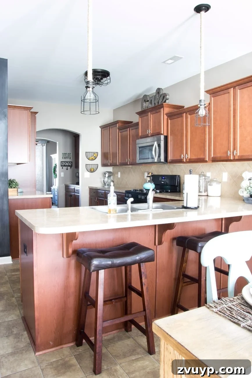 Our Stunning Modern Farmhouse Kitchen Transformation 3 The kitchen before its major farmhouse makeover, showing the dark cabinetry, beige countertops, and original lighting that contributed to a cave-like feel.