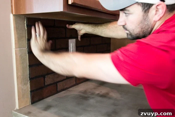 Rustic Chic Whitewashed Faux Brick Backsplash DIY 11 attaching brick paneling on top of tile to create a faux whitewashed brick backsplash