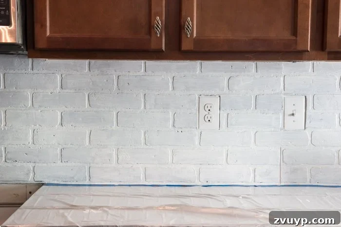 Rustic Chic Whitewashed Faux Brick Backsplash DIY 14 applying second coat of whitewash on faux brick backsplash