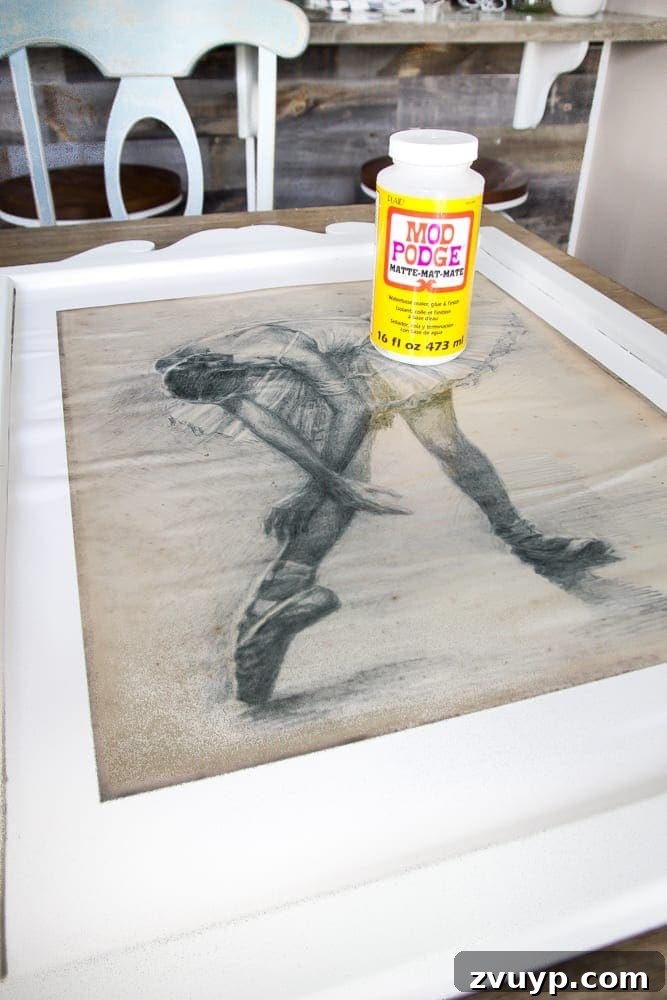 Mirror Frames Reborn as Photo Displays 8 Applying a ballerina art print to a repurposed mirror frame using Mod Podge