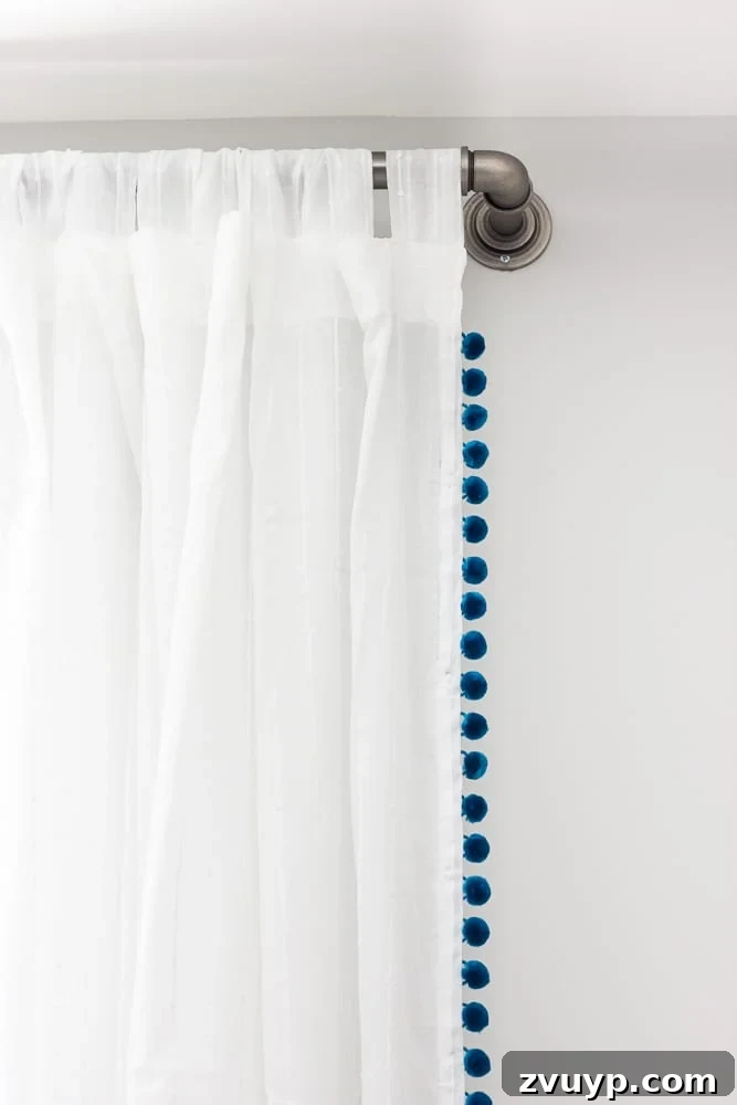 One Room Challenge Week 6 Our Eclectic Farmhouse Playroom Is Here 23 Galvanized pipe curtain rod with pom pom curtains.