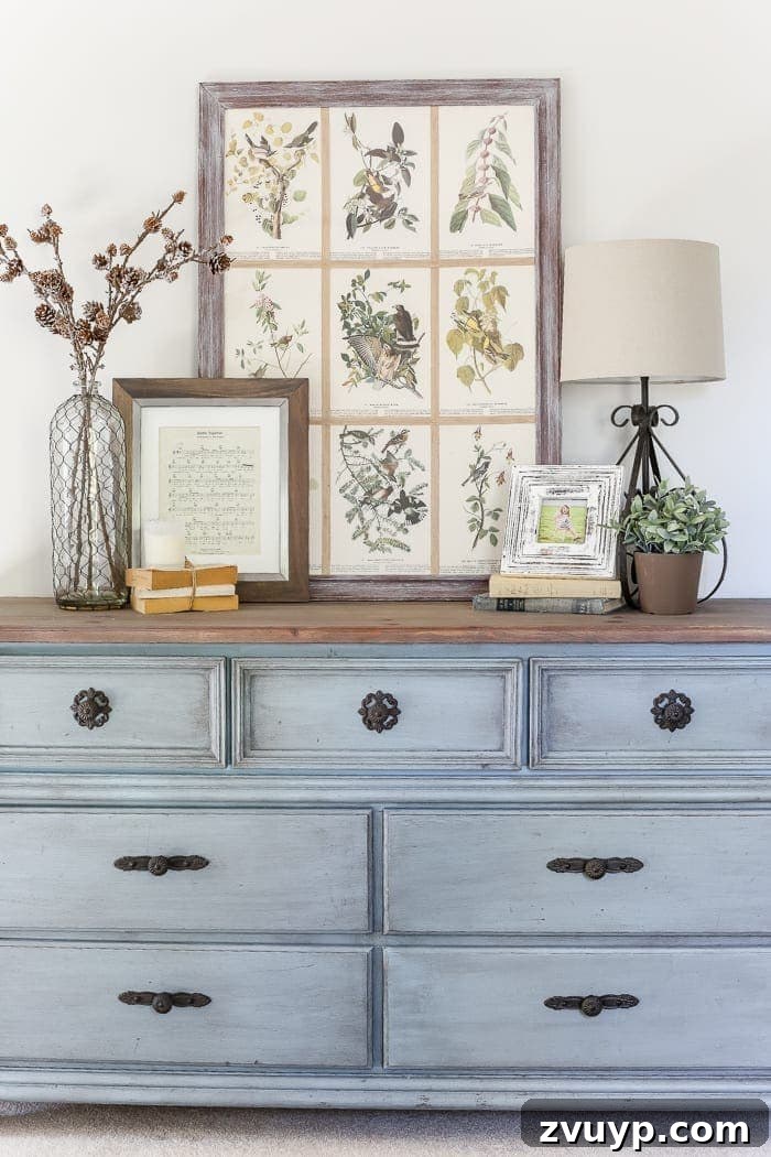 Azure Dream: My Dresser's French Blue Revival 13 French Blue Dresser Makeover | Styled French blue dresser with botanical prints and a thrift store lamp, part of a guest bedroom decor.