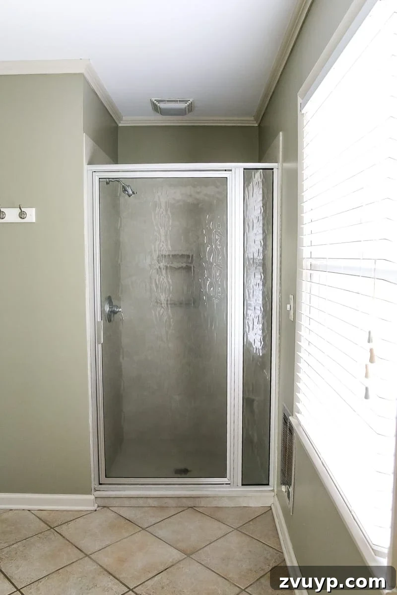 Our New Home: The Unfurnished Tour 25 Master bathroom with beige tiles, a shower, and a single vanity, targeted for immediate cosmetic updates.