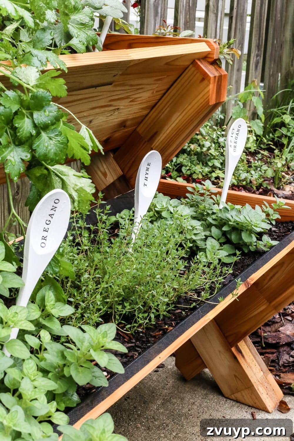 Whimsical Wooden Spoon Garden Labels 10 DIY Wooden Spoon Garden Markers | A close-up of a stacked herb garden, showcasing various herbs thriving with their DIY wooden spoon labels.