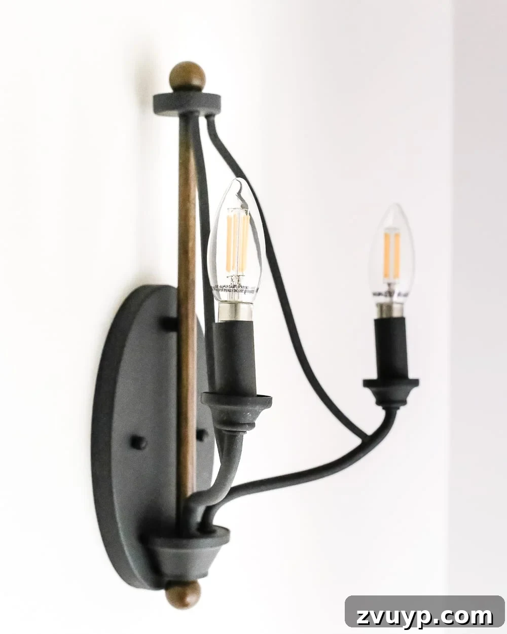 A Fresh Welcome: Our Neutral Foyer Makeover 9 Modern black and wood sconce with Edison style LED bulb on a staircase landing.