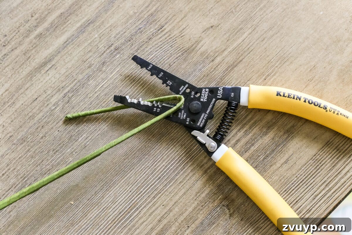 Craft Your Own Olive Topiary 4 Trimming faux olive branch stems with wire cutters to customize topiary height.