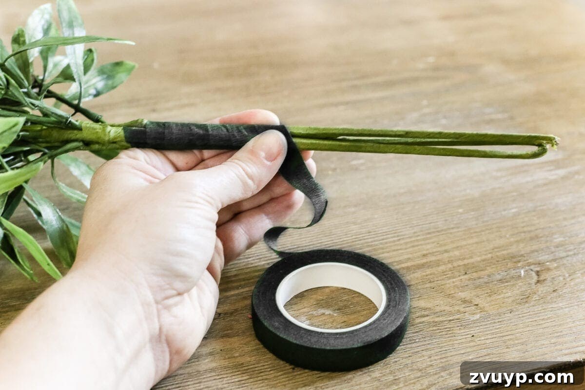 Craft Your Own Olive Topiary 5 Bundling faux olive branch stems together with floral tape for stability.