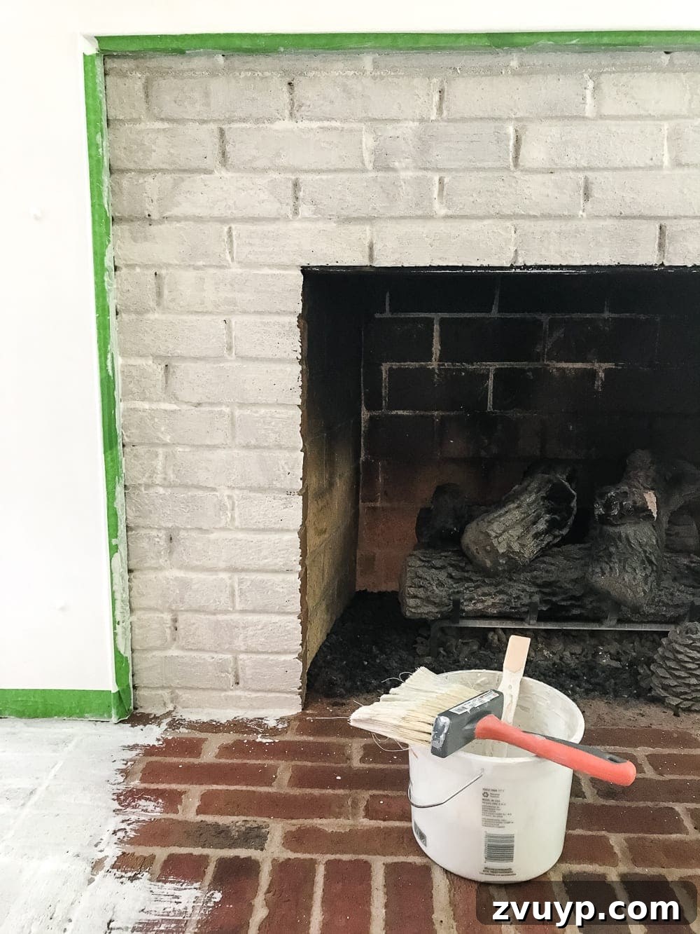 painting lime wash on natural bricks on a fireplace