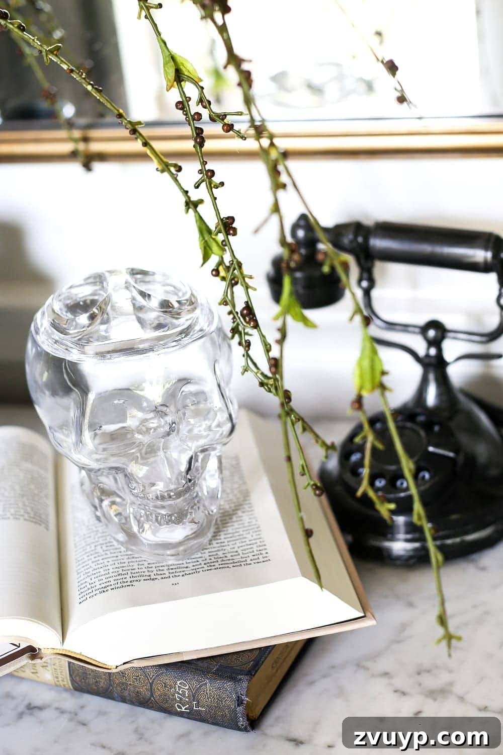 Marbled Wonders for a Haunted Welcome 12 Edgar Allan Poe book collection next to an empty glass skull candy jar