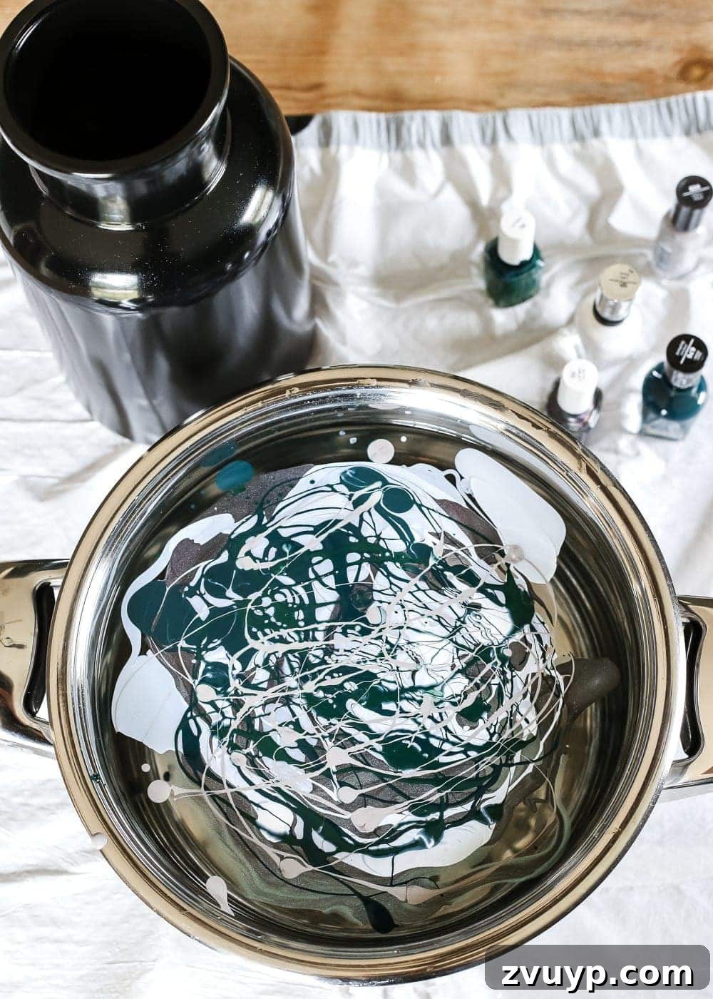Marbled Wonders for a Haunted Welcome 7 Nail polish colors floating on the surface of water in a pot