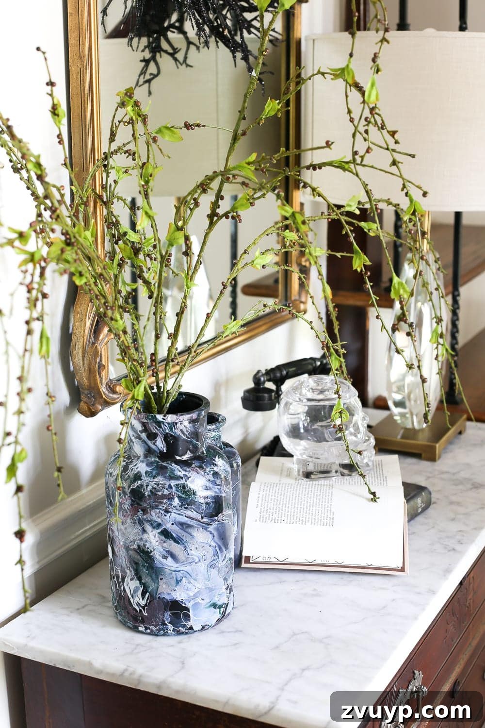 Marbled Wonders for a Haunted Welcome 10 Detailed shot of Halloween entryway decor with marbled vases, skull, and vintage phone