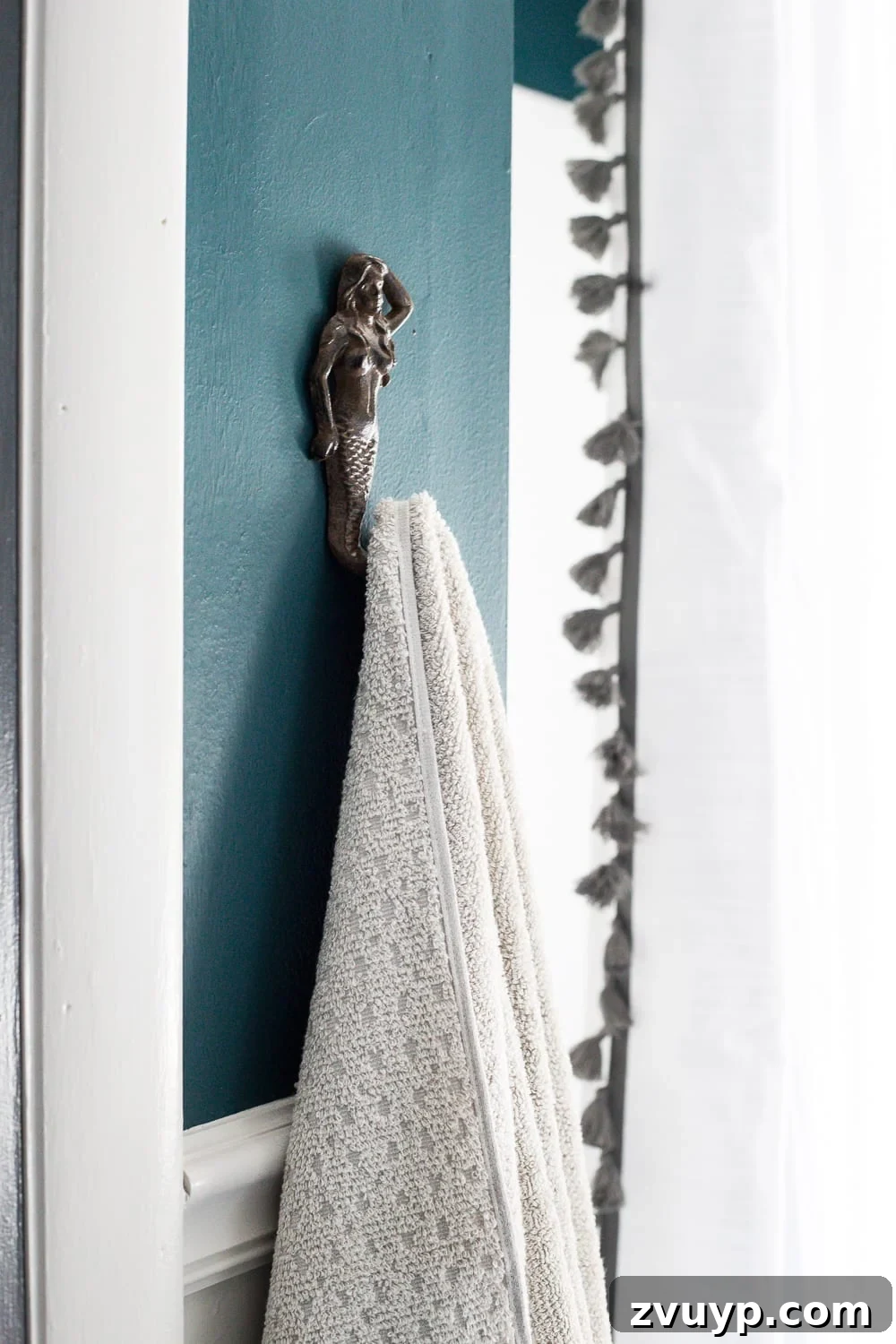 Kid Friendly and Guest Ready Bathroom Makeover 15 Mermaid Towel Hook in Bathroom: Cast iron mermaid hook adds a whimsical and functional touch next to the shower. #mermaidbathroom #towelhook #bathroomdetails