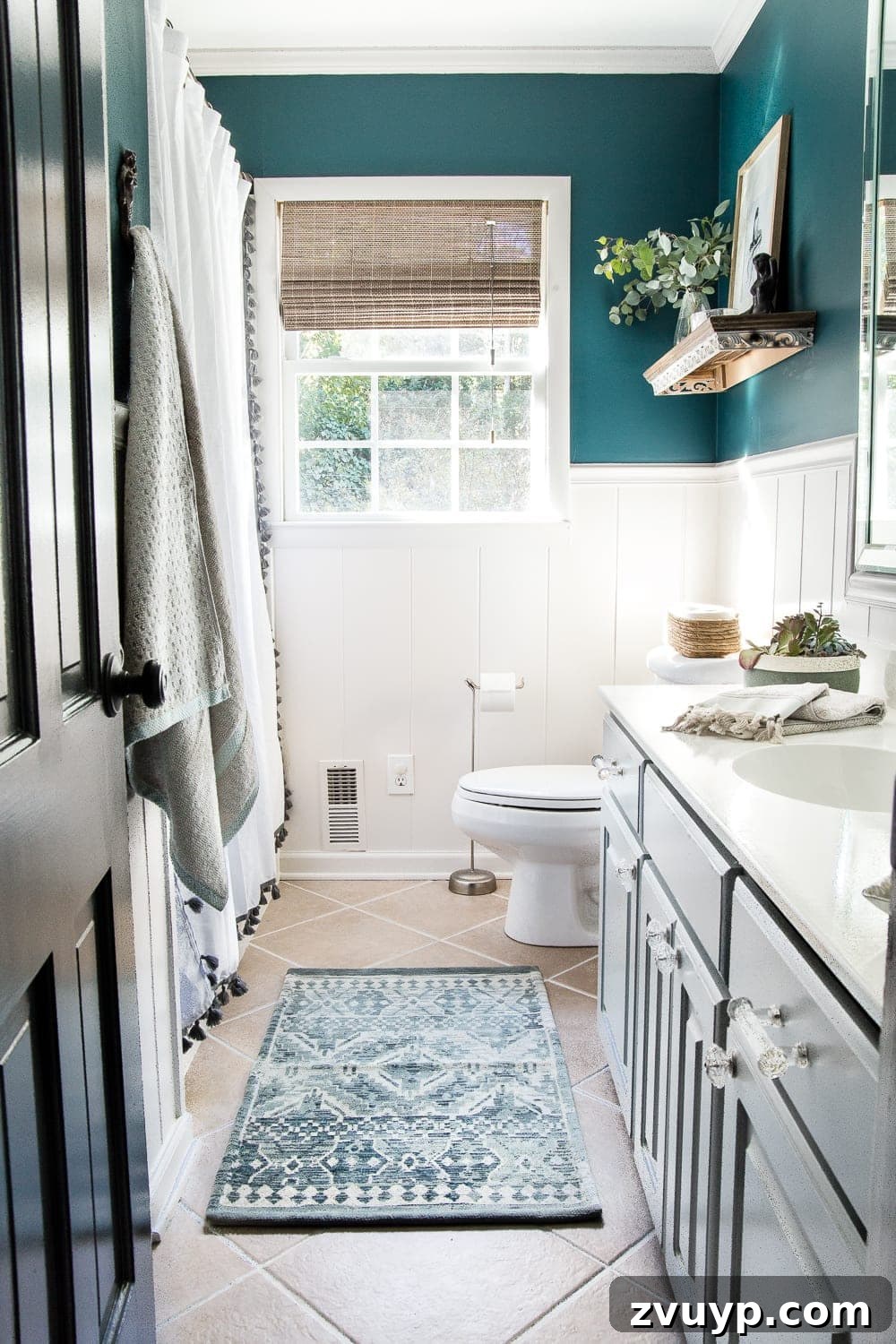 Kid Friendly and Guest Ready Bathroom Makeover 4 Kid's / Guest Bathroom Vanity After: Featuring a deep teal wall, white wainscoting, painted cabinets, and charming mermaid-inspired accessories. #bathroomdesign #homedecor #mermaidtheme