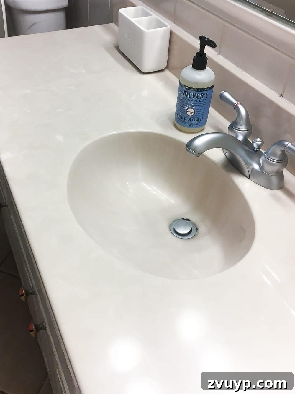 Kid Friendly and Guest Ready Bathroom Makeover 10 Before Bathroom Floor and Vanity: Shows the original beige sink, countertop, and dingy tiled floor before the budget-friendly makeover. #bathroomremodel #diyfloor #oldbathroom