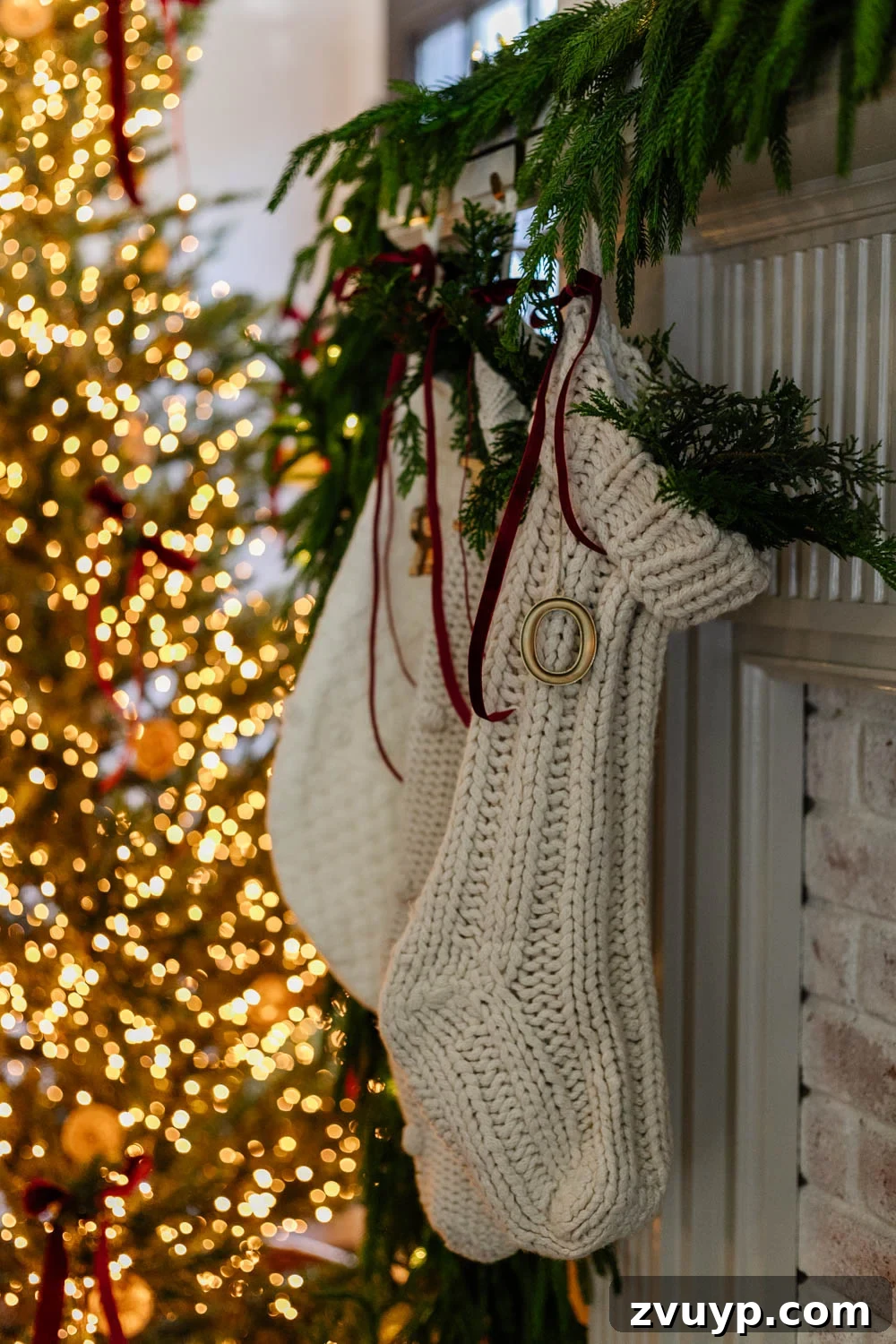250 Essential Stocking Stuffers for Your Family's 2025 Holiday 3 christmas stockings on a mantel with red ribbon