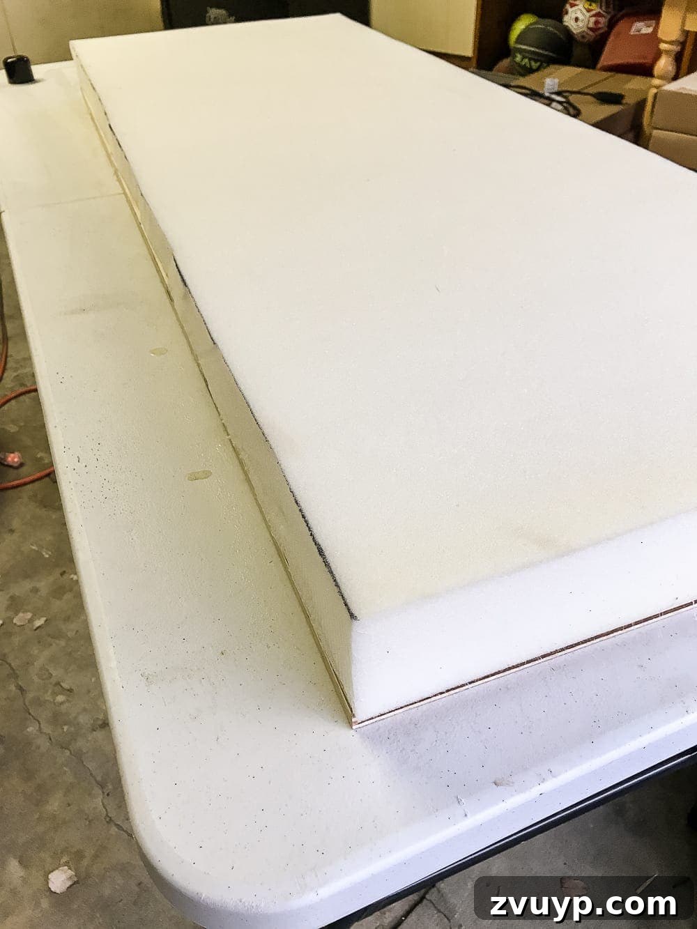 From Coffee Table to Ottoman An Easy DIY Transformation 13 Applying Spray Adhesive to Foam and Plywood