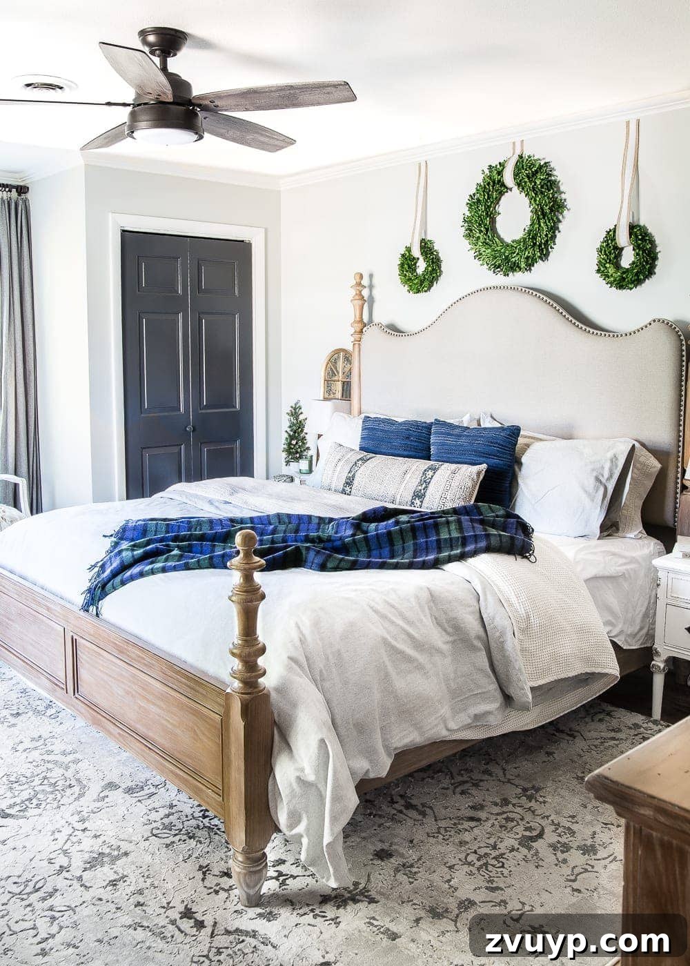 Cozy Blue and Neutral Christmas Sanctuary 14 Cozy Blue Christmas Bedroom with Warm Lighting | blesserhouse.com - A wide shot of a master bedroom adorned with blue, neutral, and green Christmas decor, inviting warmth and tranquility for the winter season.