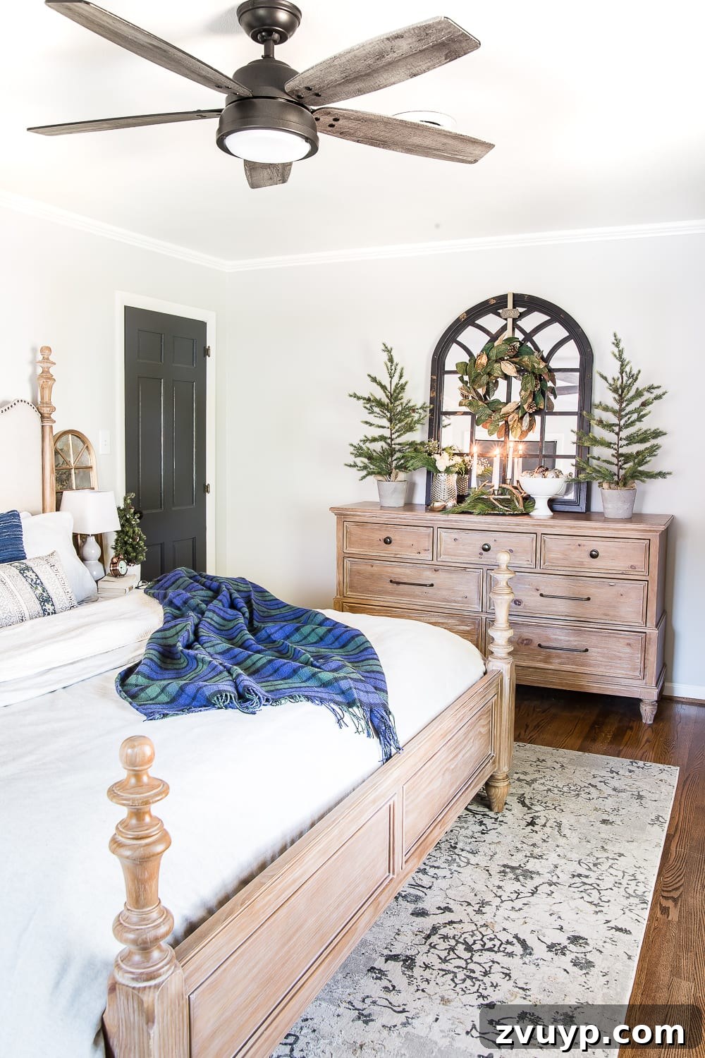 Cozy Blue and Neutral Christmas Sanctuary 8 Cozy Nightstand with Blue Christmas Decor and Soft Lighting | blesserhouse.com - A beautifully styled nightstand in a Christmas-decorated bedroom, featuring a warm lamp, mini tree, and a serene color palette.