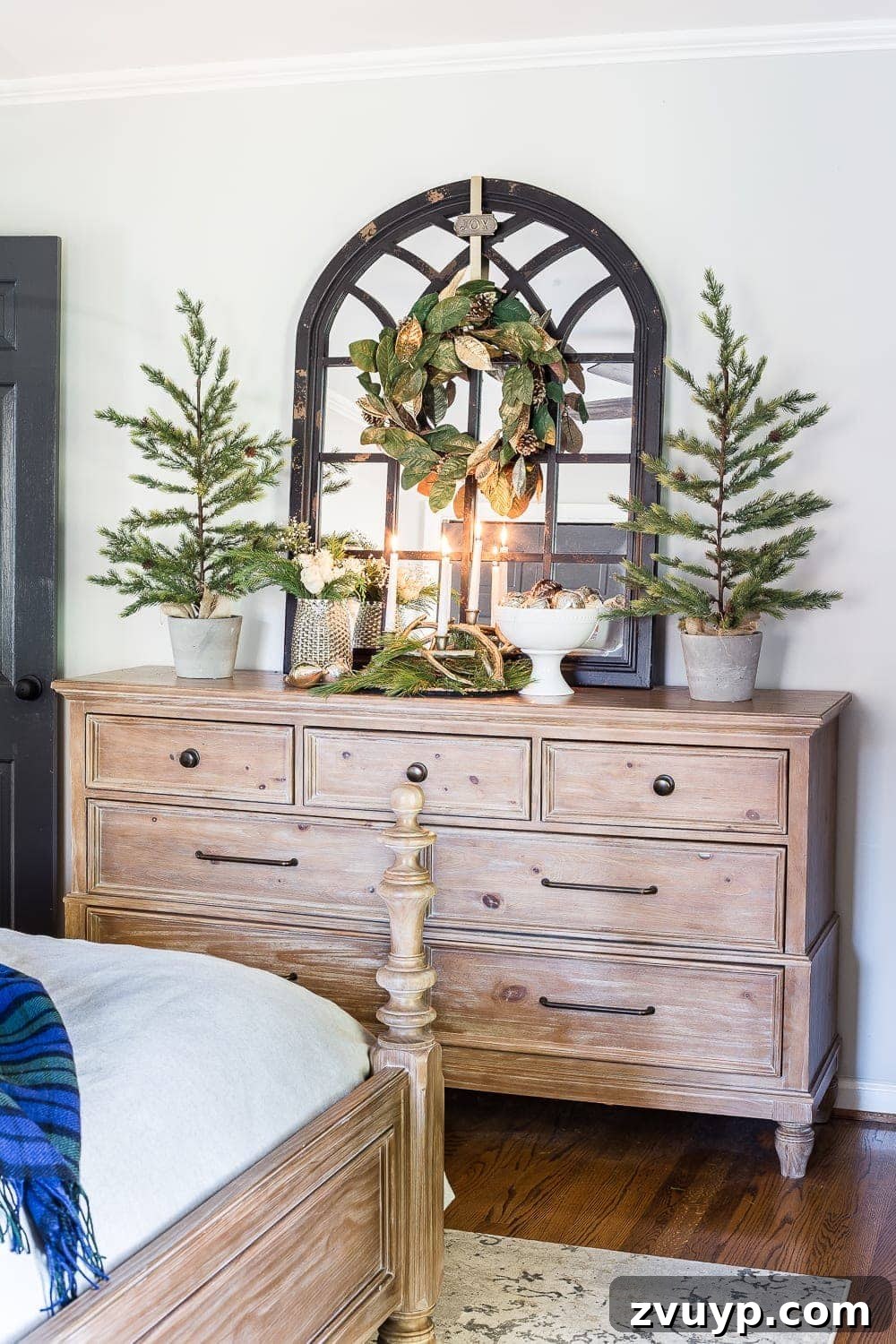 Cozy Blue and Neutral Christmas Sanctuary 9 Dresser Decor with Tabletop Trees and Magnolia Wreath in Christmas Bedroom | blesserhouse.com - A dresser styled with tabletop Christmas trees, a magnolia wreath, and a white pedestal bowl, enhancing the festive bedroom atmosphere.