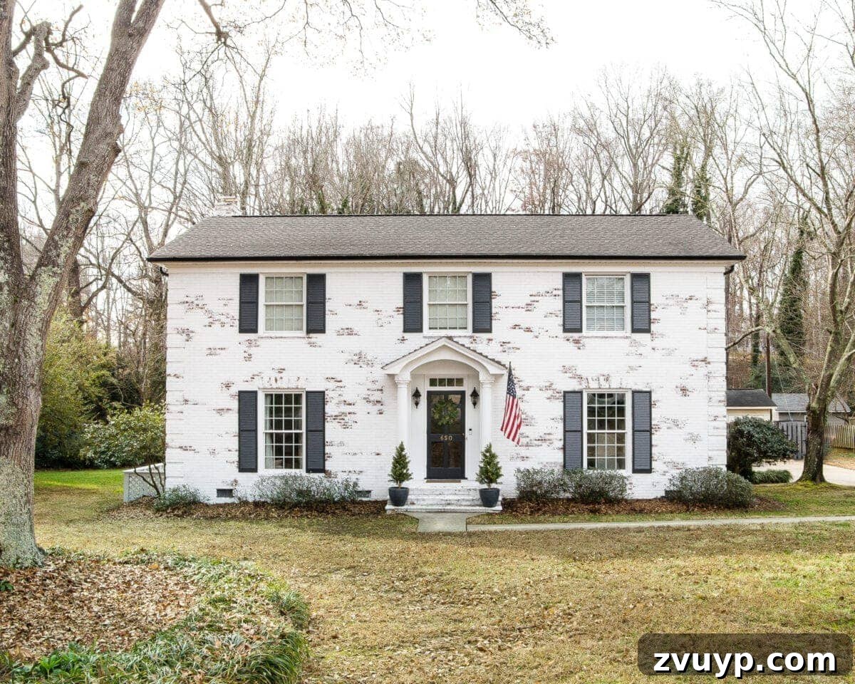 Limewash Magic: Our Brick Exterior Transformed 2 Romabio Bianco White limewash brick with Behr Cracked Pepper shutters and gutters and Behr Ultra Pure White trim