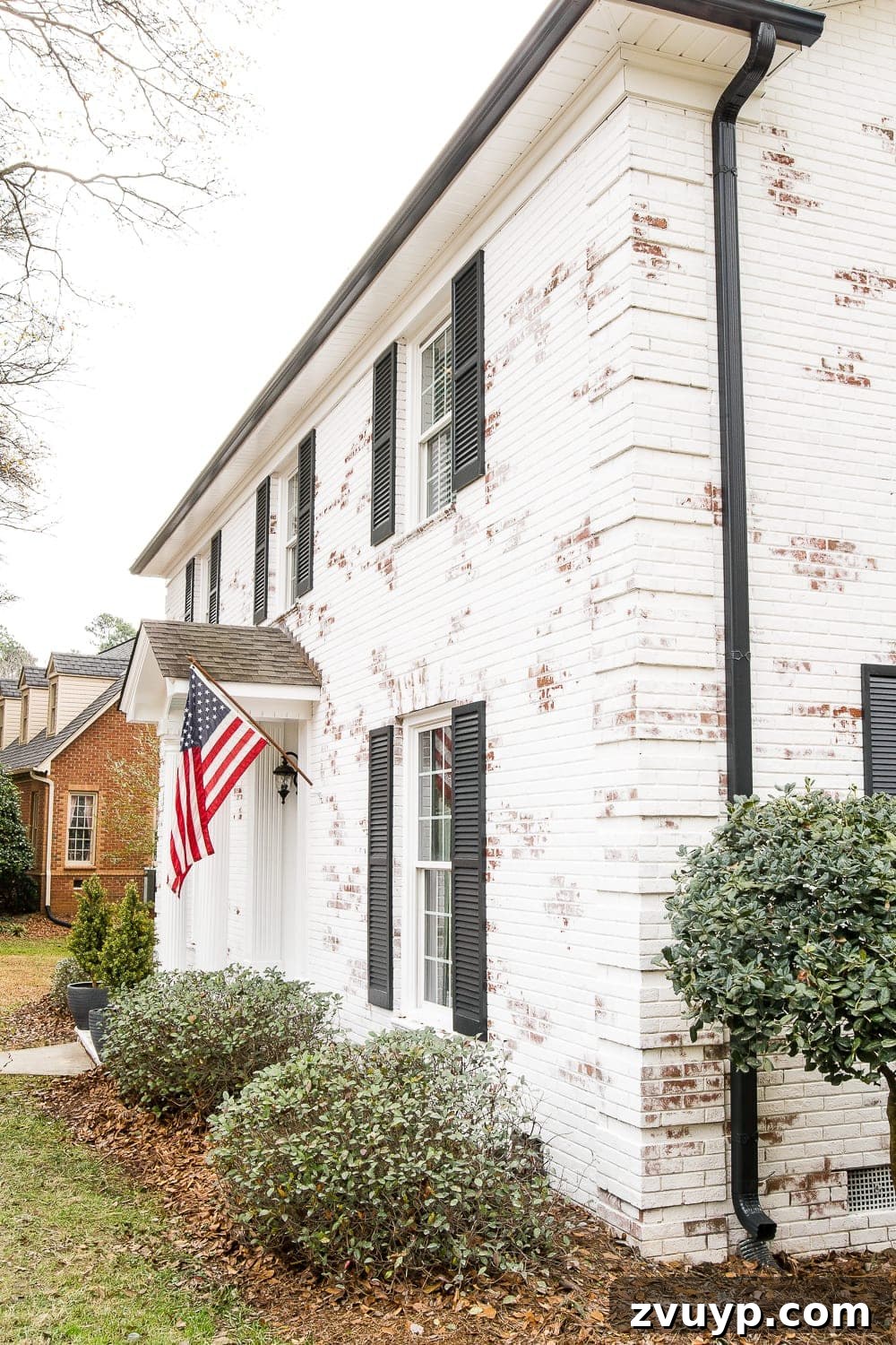 Limewash Magic: Our Brick Exterior Transformed 13 Romabio Bianco White brick with Behr Cracked Peppercorn Shutters and Gutters and Behr Ultra Pure White trim