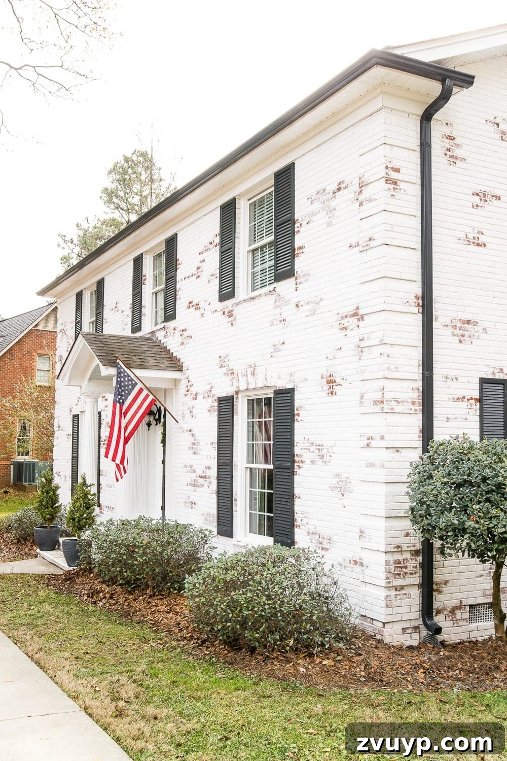 Limewash Magic: Our Brick Exterior Transformed 18 White brick colonial house with black shutters and black gutters